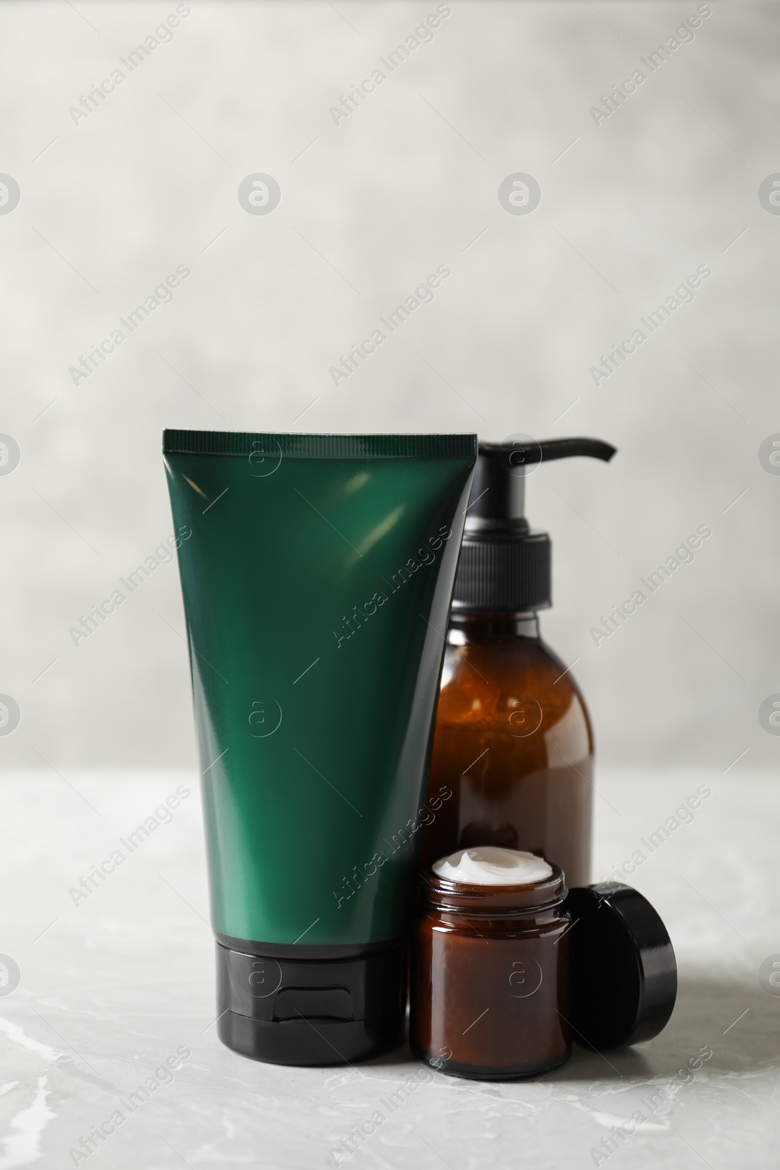 Photo of Facial cream and other men's cosmetic on light marble table. Mockup for design