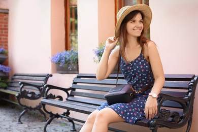 Photo of Young woman resting on wooden bench outdoors