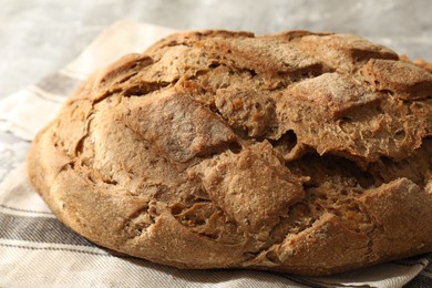 Freshly baked sourdough bread and napkin on table, closeup