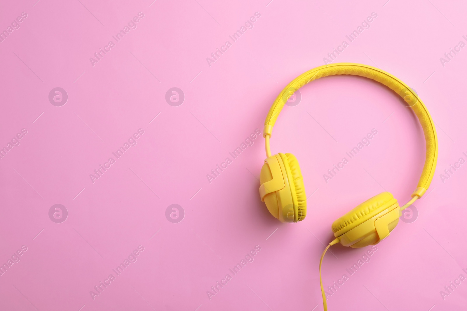 Photo of Stylish headphones on color background, top view. Space for text