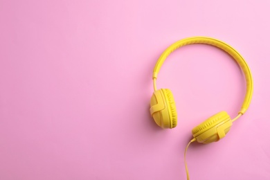 Photo of Stylish headphones on color background, top view. Space for text