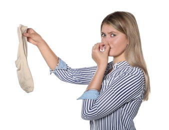 Young woman feeling bad smell from dirty socks isolated on white
