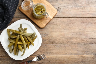 Photo of Canned green beans on wooden table, flat lay. Space for text