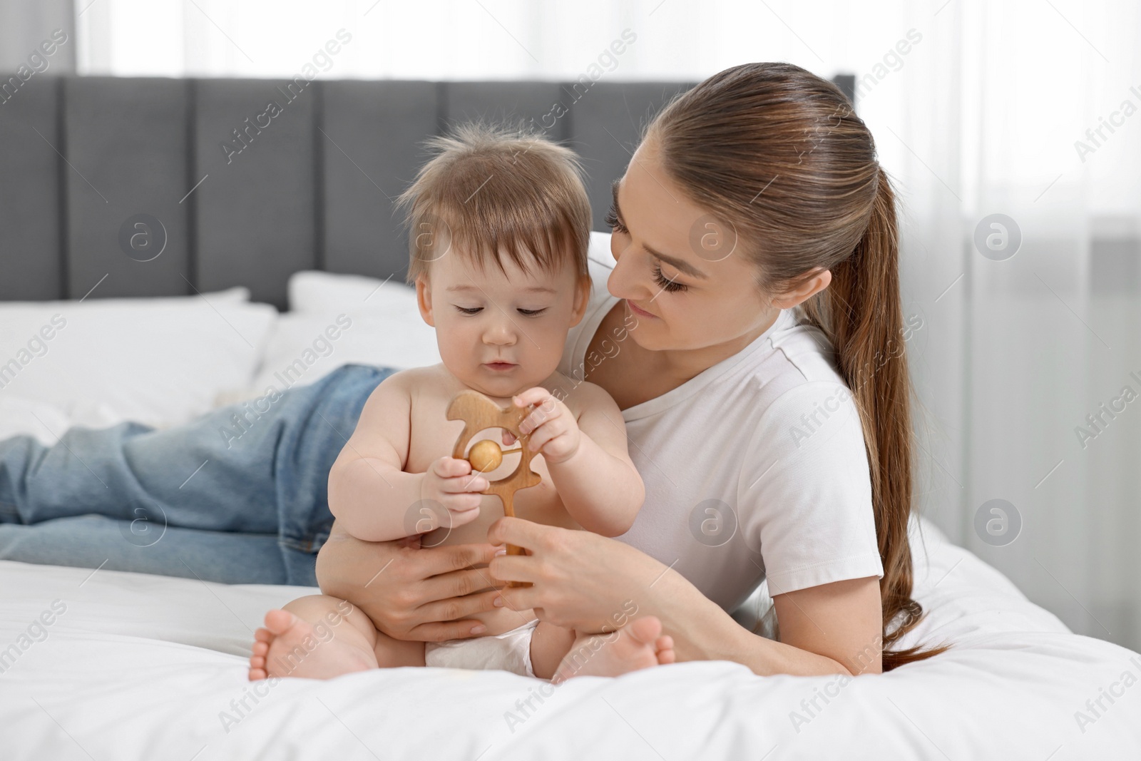 Photo of Mother with her baby on bed at home