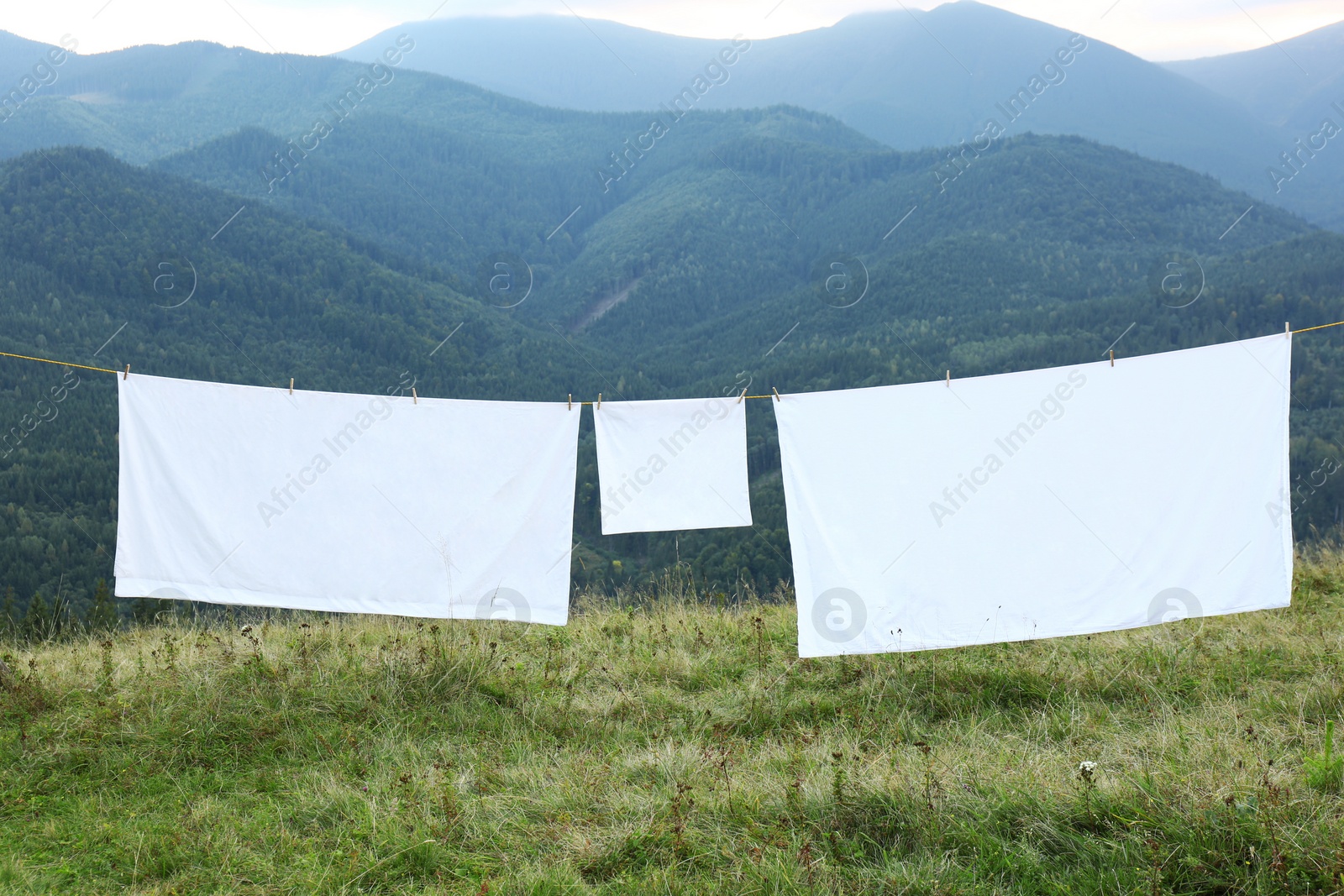 Photo of Bedclothes hanging on washing line in mountains