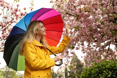 Young woman with umbrella in park on spring day