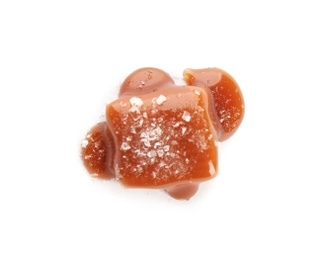 Photo of Delicious candy with caramel sauce and salt on white background, top view