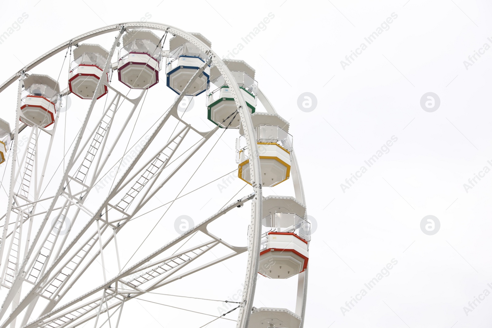 Photo of Large white observation wheel against sky, space for text