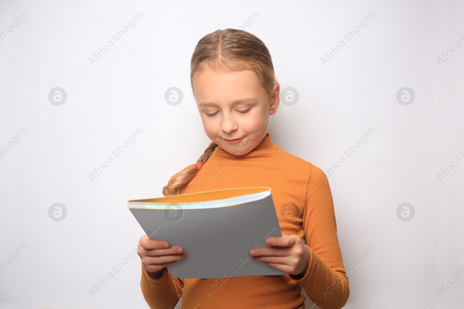 Photo of Little girl reading book on white background