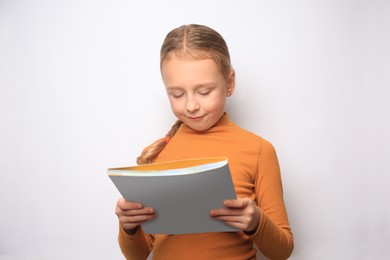 Little girl reading book on white background