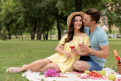 Photo of Happy young couple having picnic in park on summer day