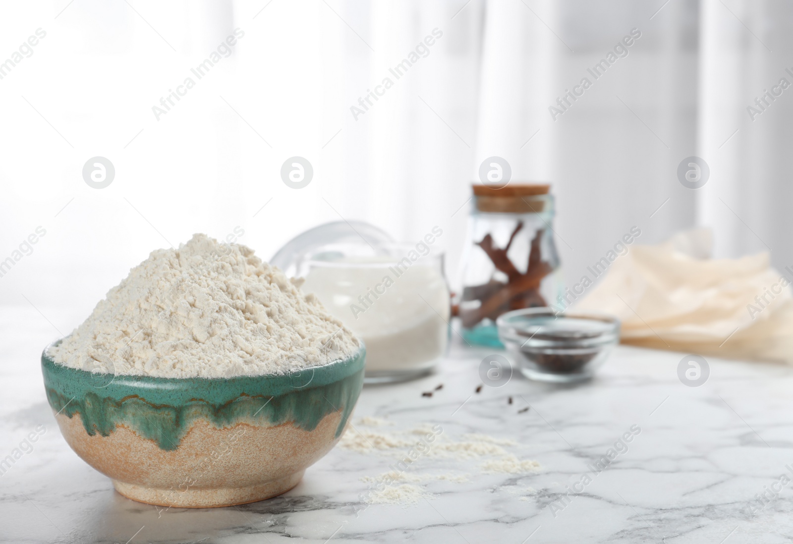 Photo of Bowl with flour on kitchen table