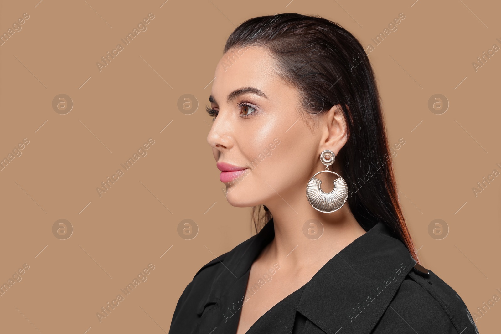 Photo of Portrait of young woman with beautiful makeup on light brown background. Space for text