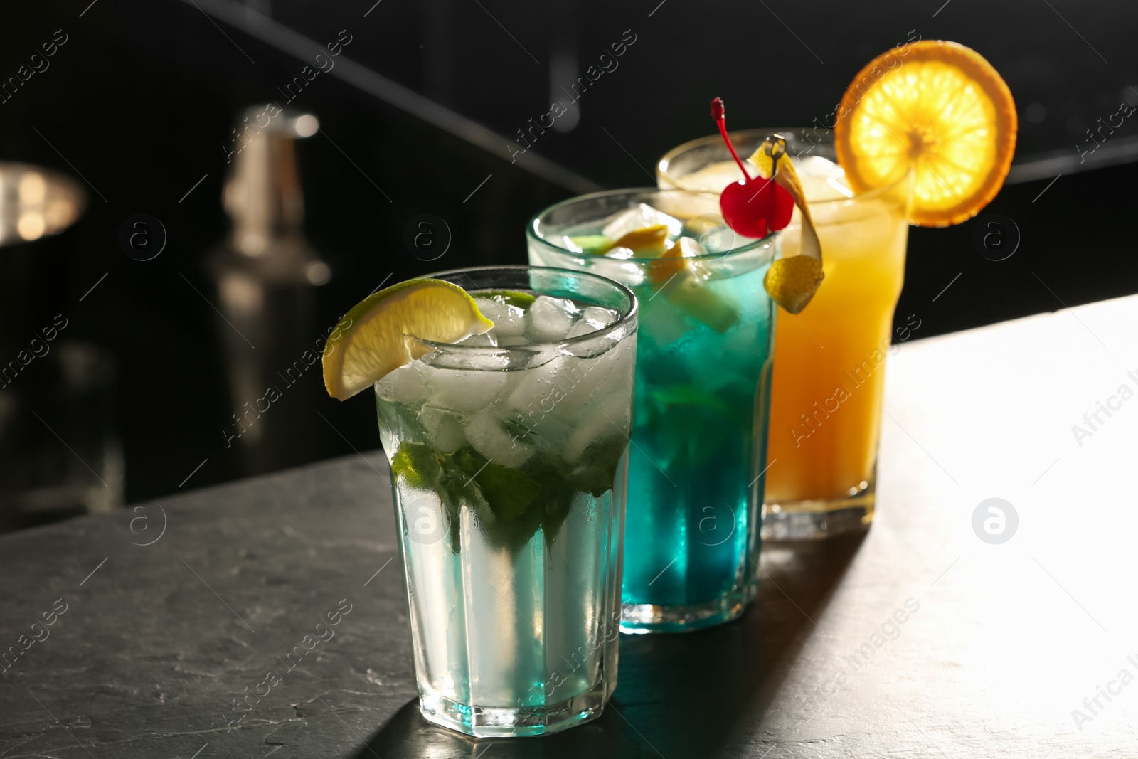 Photo of Different delicious cocktails on counter in bar