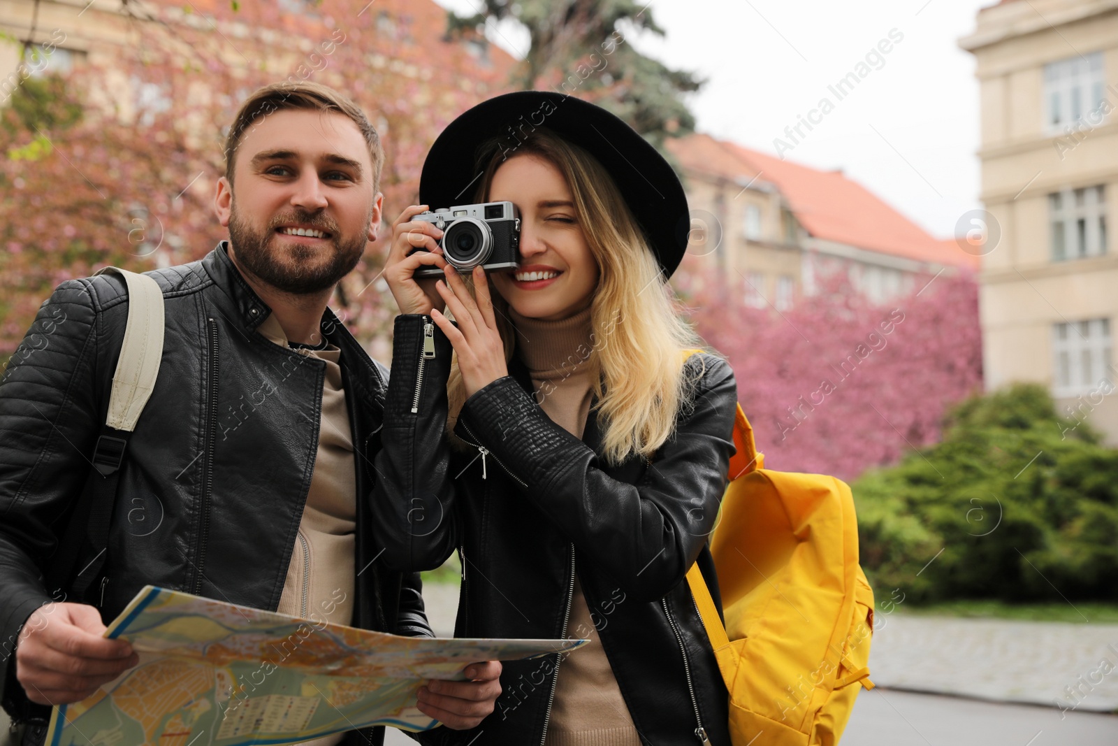 Photo of Couple of tourists with map and camera on city street