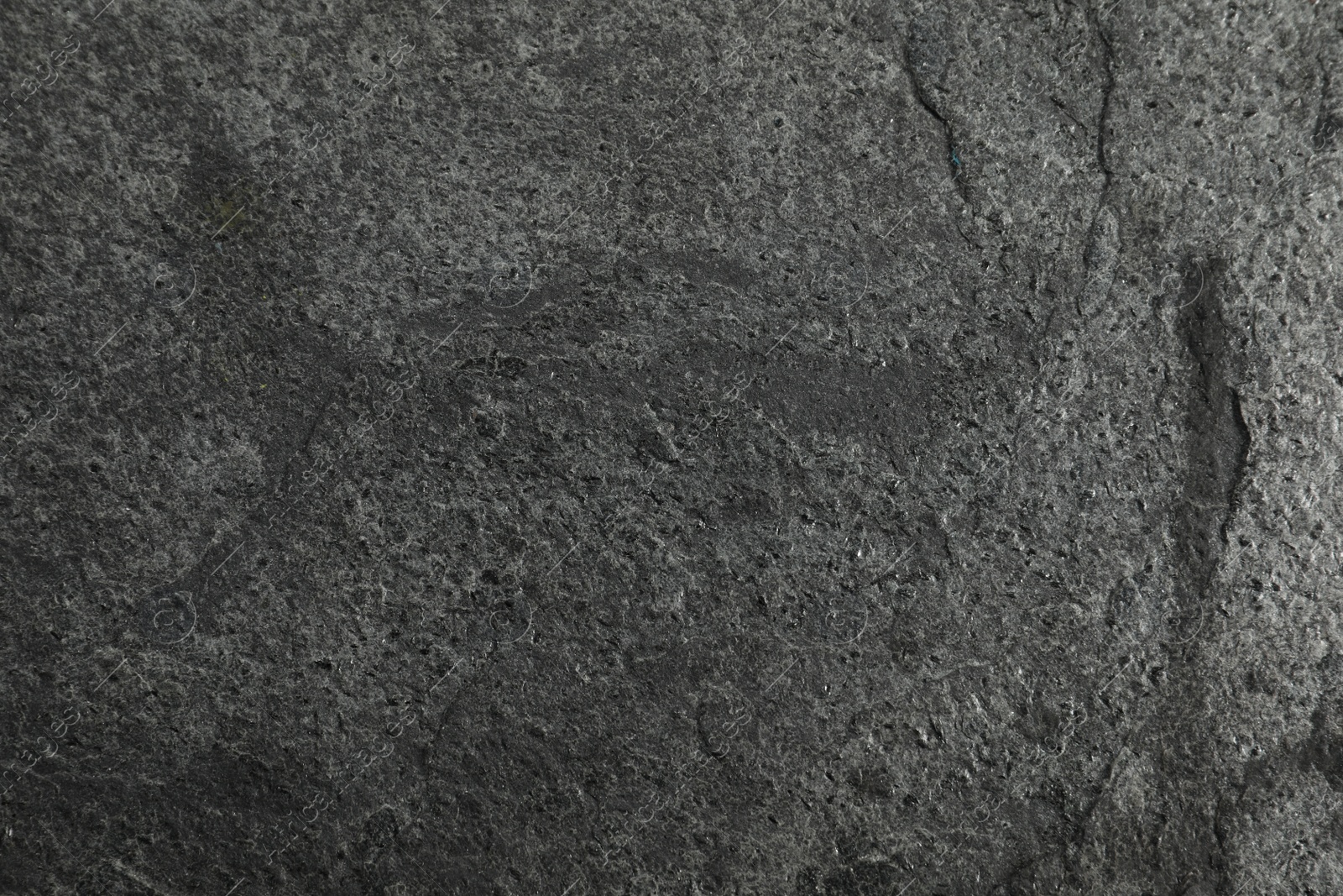 Photo of Texture of dark grey stone surface as background, closeup