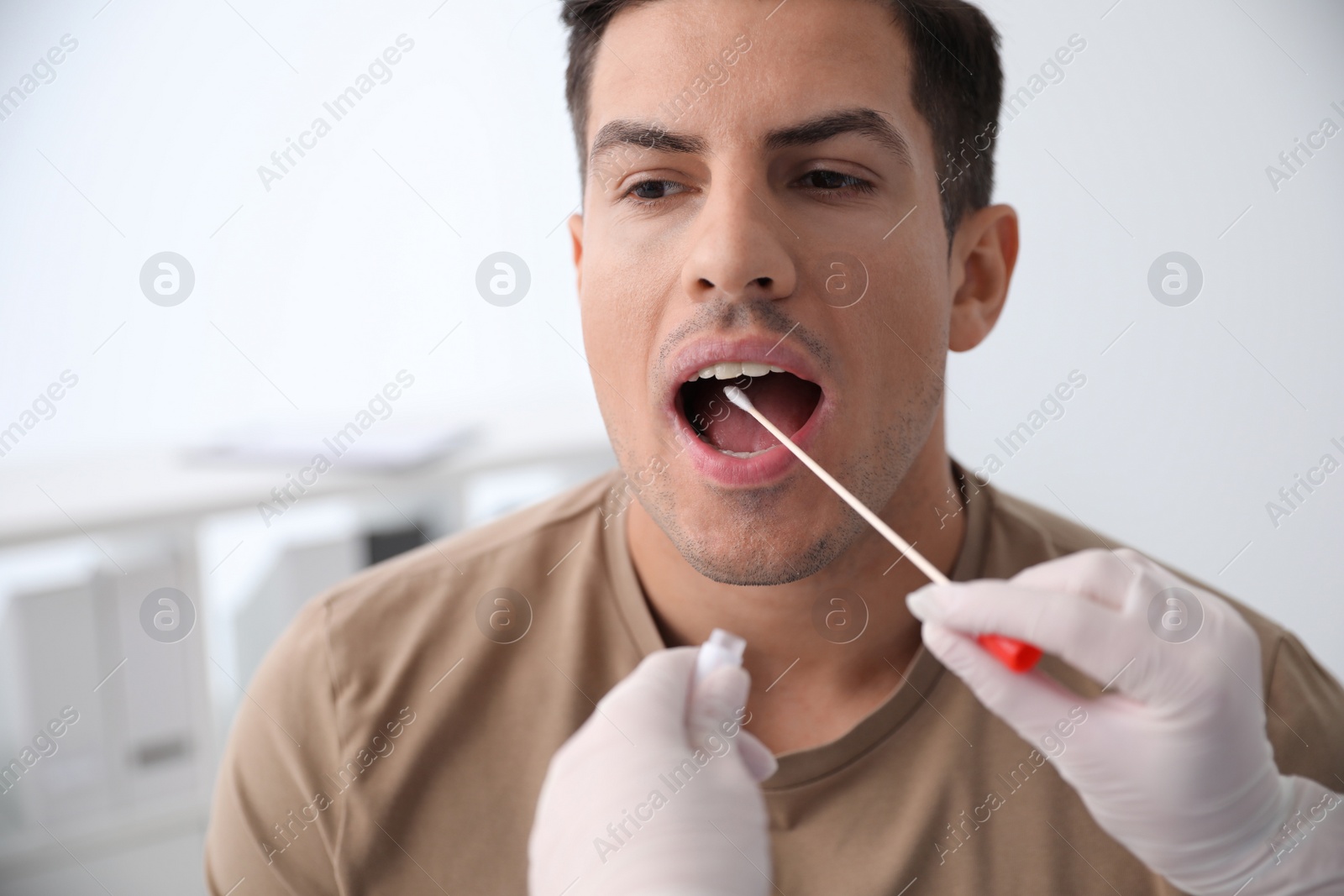 Photo of Doctor taking sample for DNA test from man in clinic