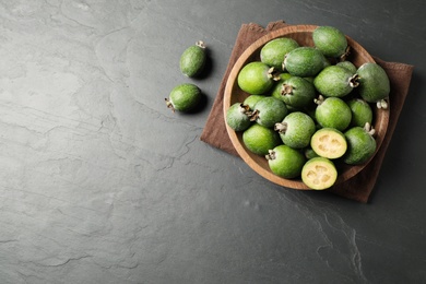 Photo of Delicious fresh feijoas on black table, flat lay. Space for text