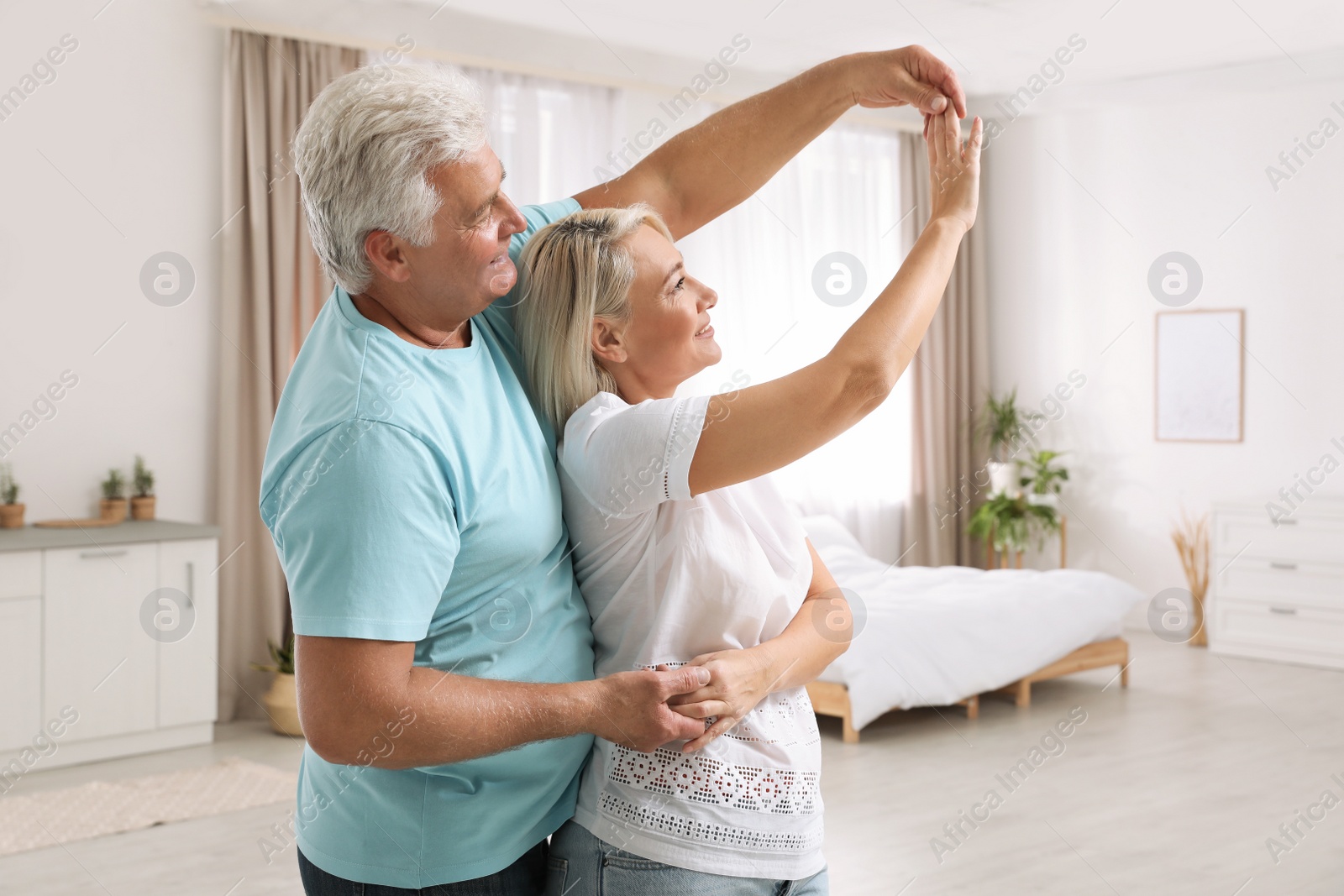 Photo of Happy mature couple dancing together at home