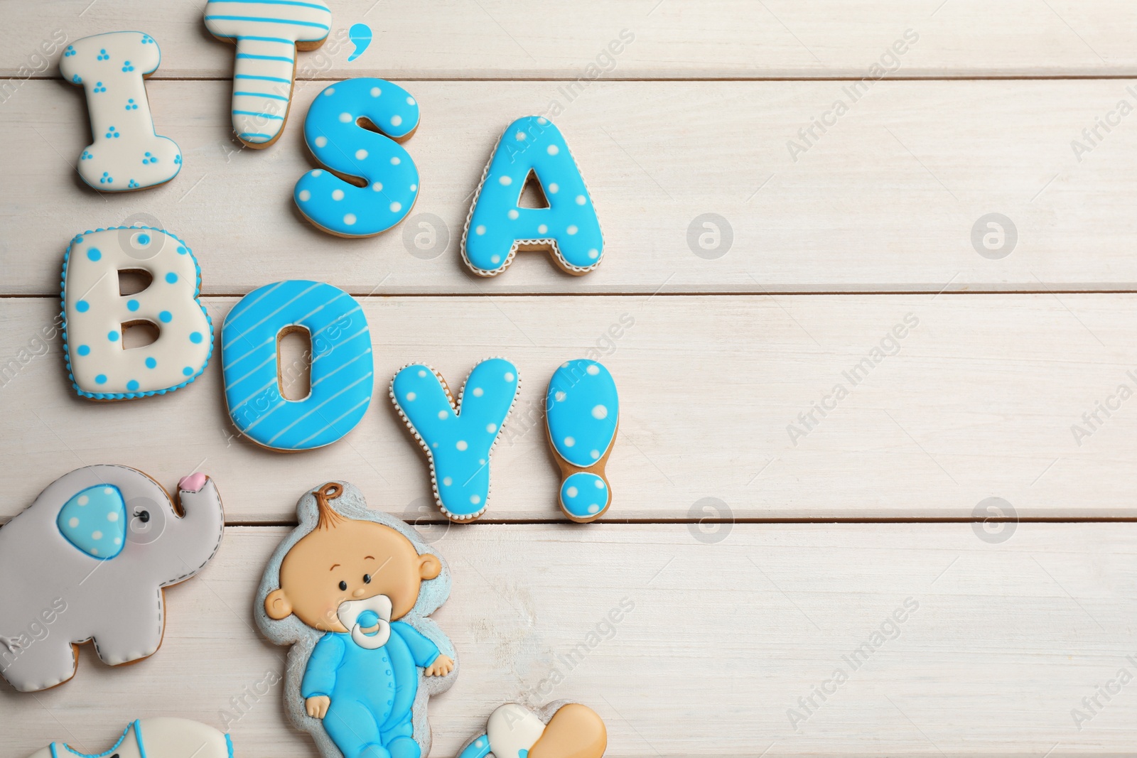 Photo of Phrase It is a boy, tasty cookies and space for text on white wooden table, flat lay. Baby shower party