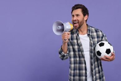 Emotional sports fan with soccer ball and megaphone on purple background, space for text