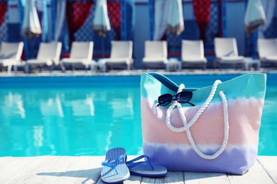 Photo of Beach accessories near swimming pool on sunny day. Space for text