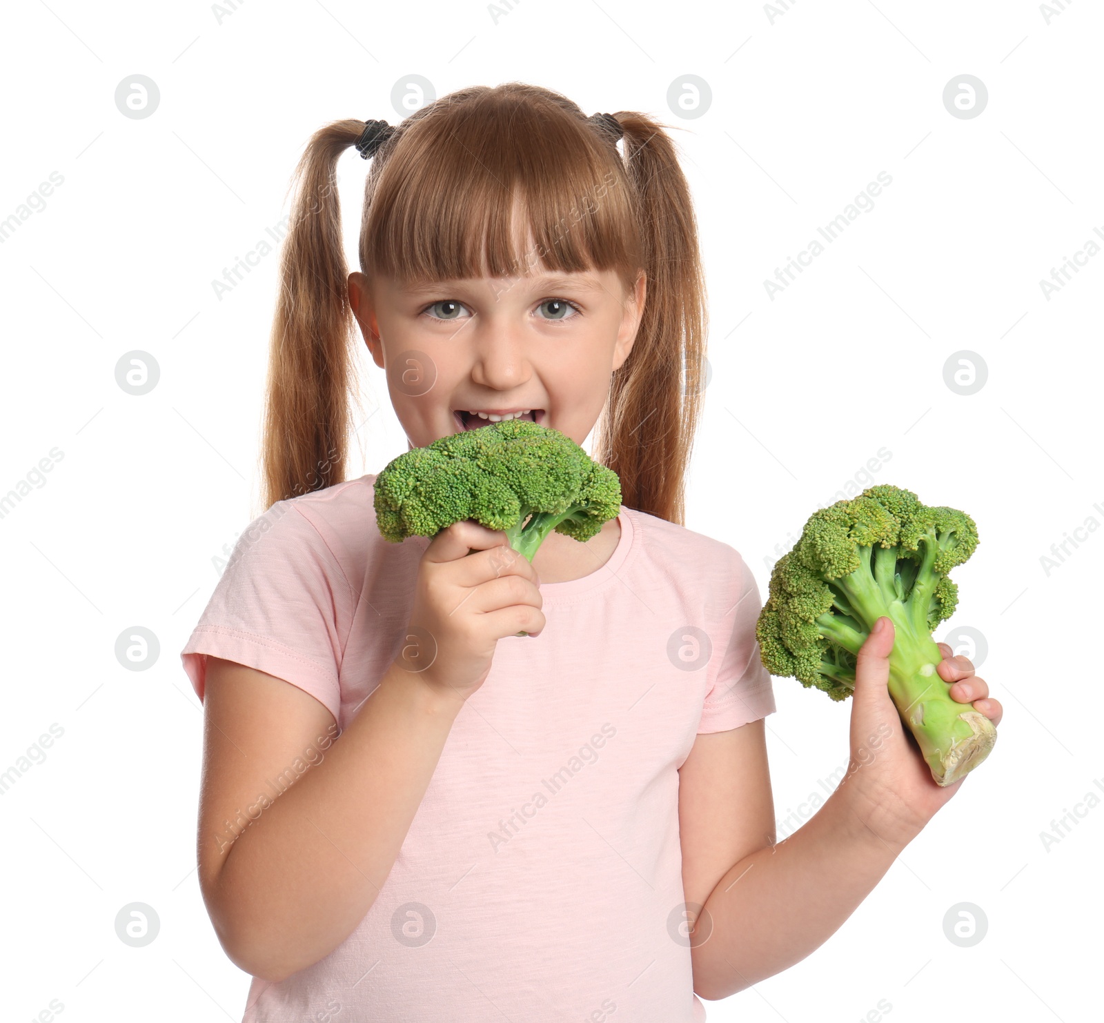 Photo of Portrait of cute little girl biting broccoli on white background