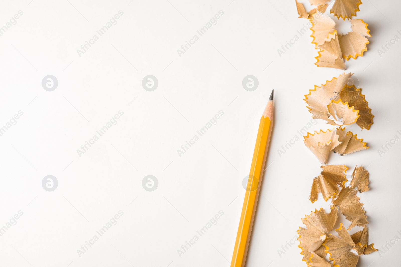 Photo of Pencil and shavings on white background, top view