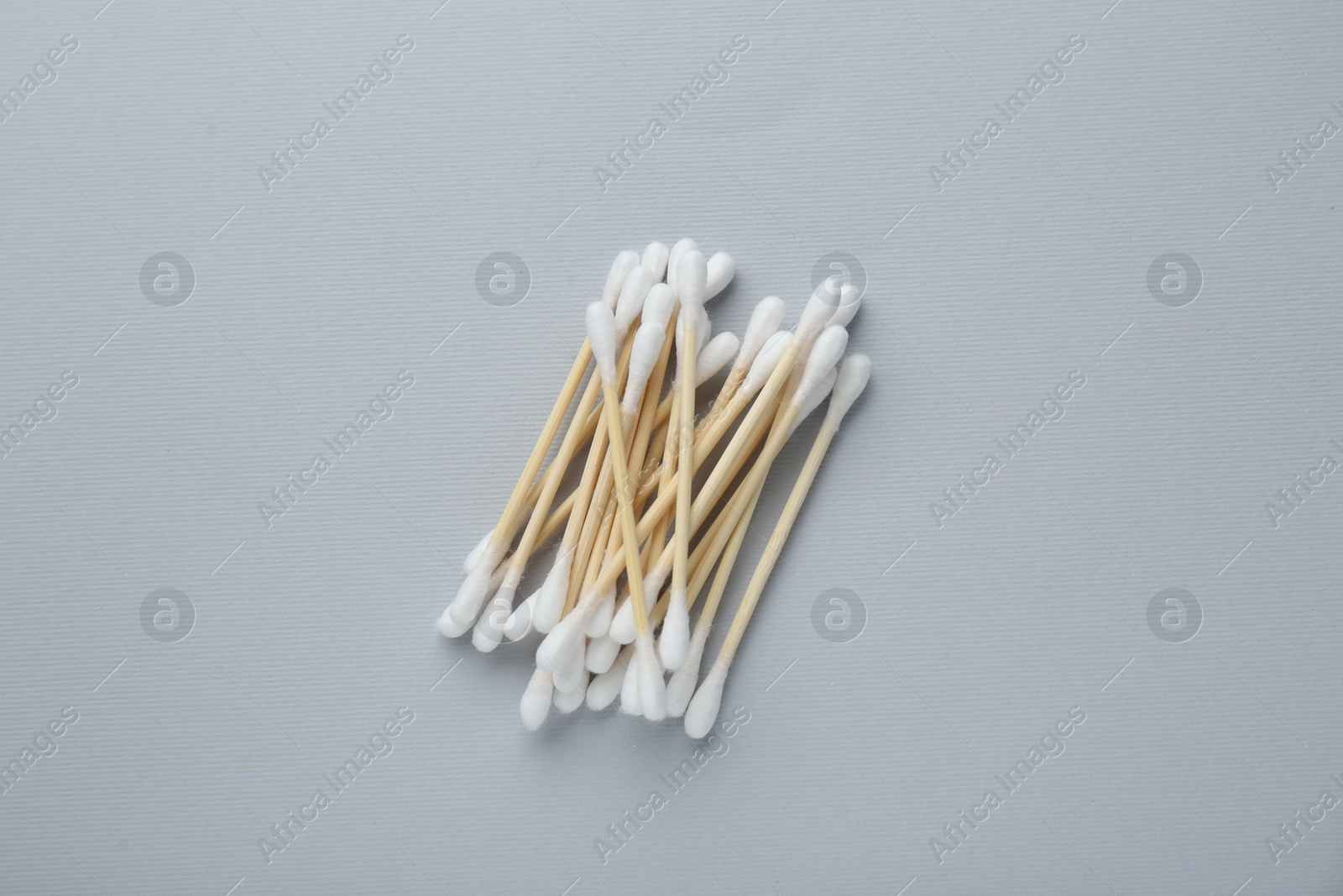 Photo of Many wooden cotton buds on light grey background, flat lay