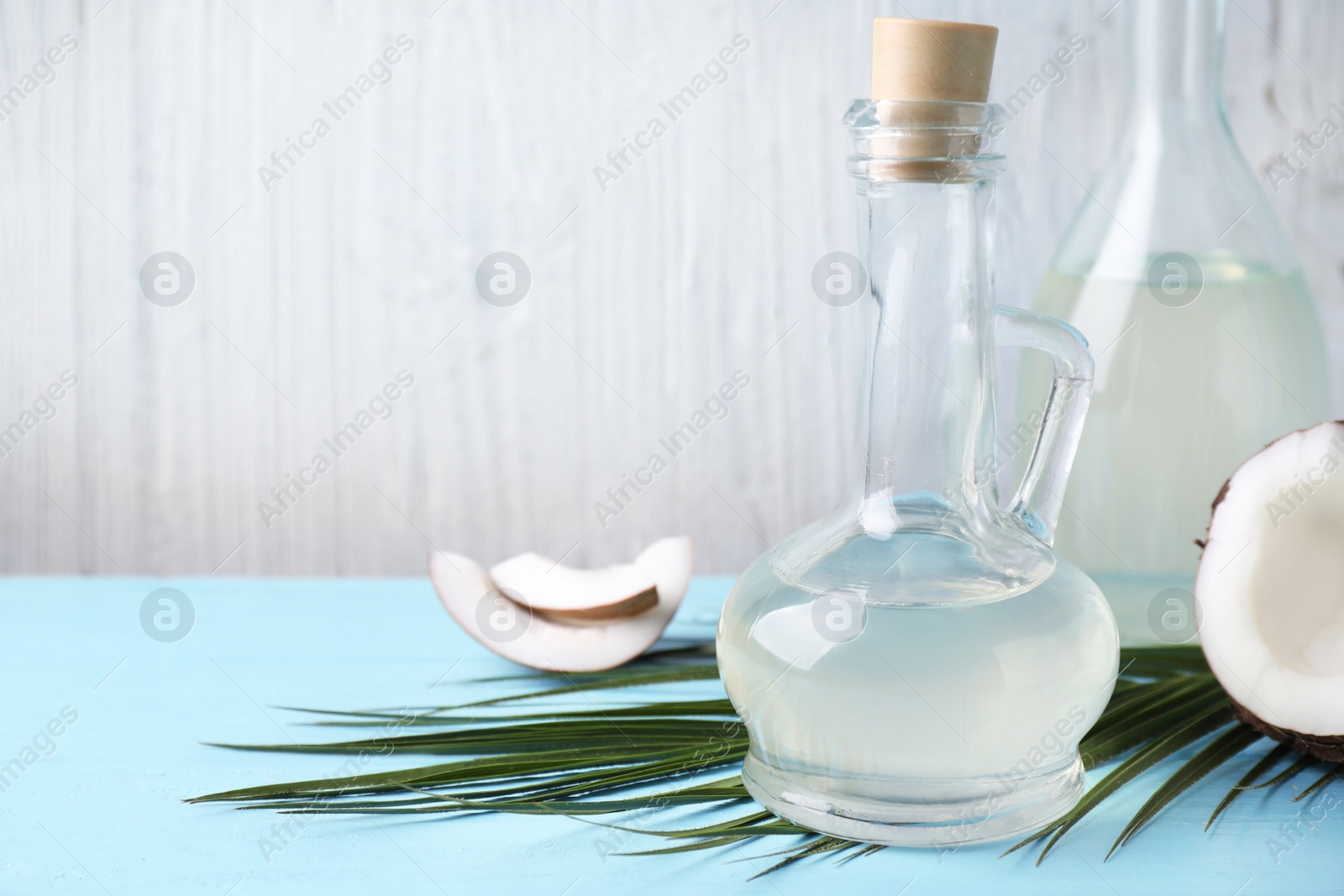 Photo of Coconut oil on light blue wooden table. Space for text