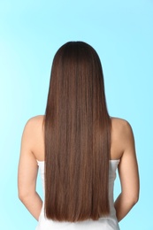 Woman with long brown hair on color background