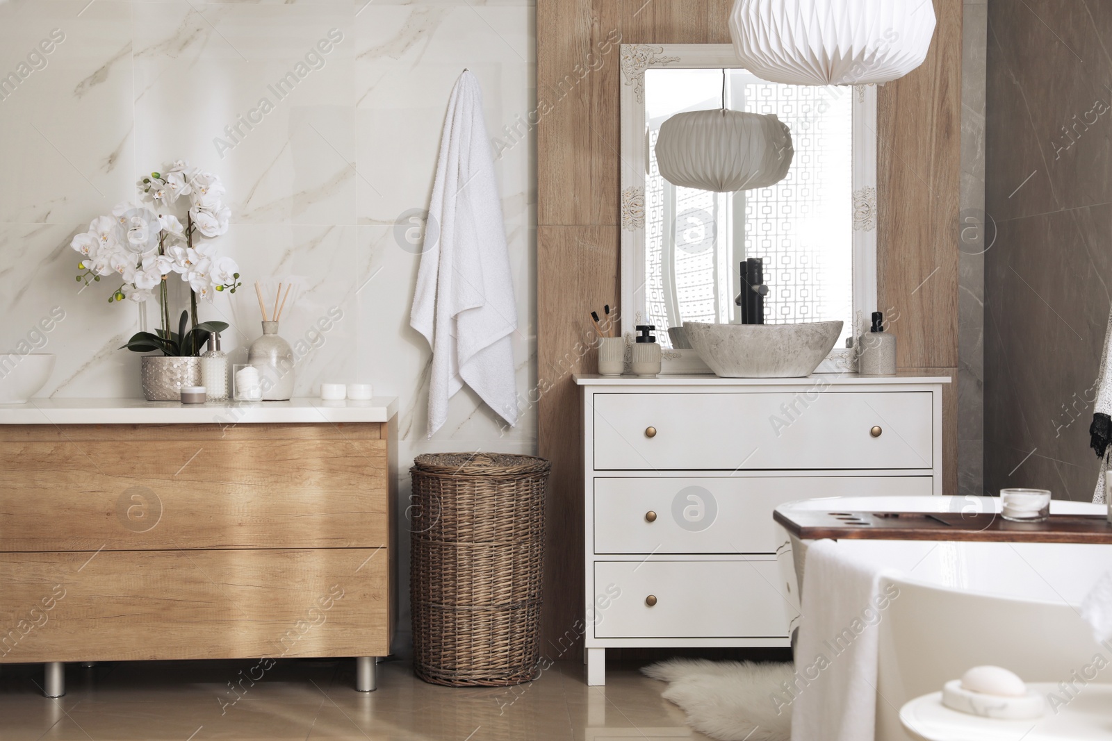 Photo of Modern white tub and chest of drawers with sink in bathroom. Interior design