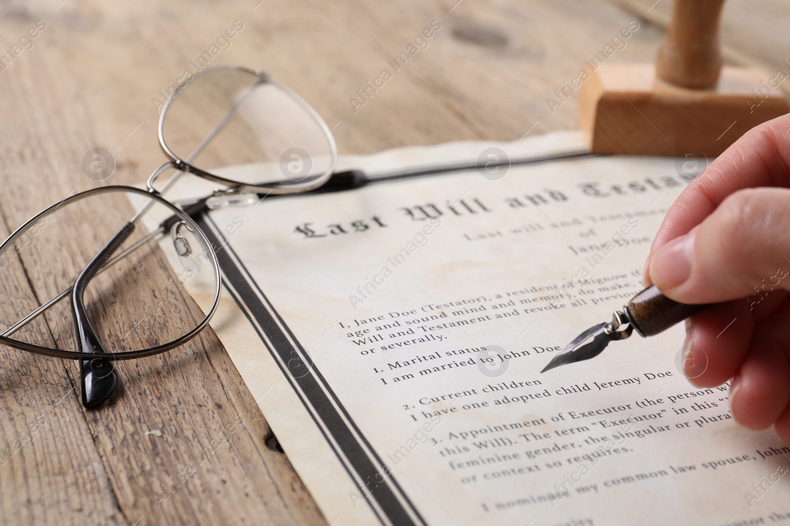 Photo of Woman signing Last Will and Testament at wooden table, closeup