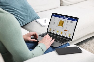 Photo of Man with laptop shopping online indoors, closeup