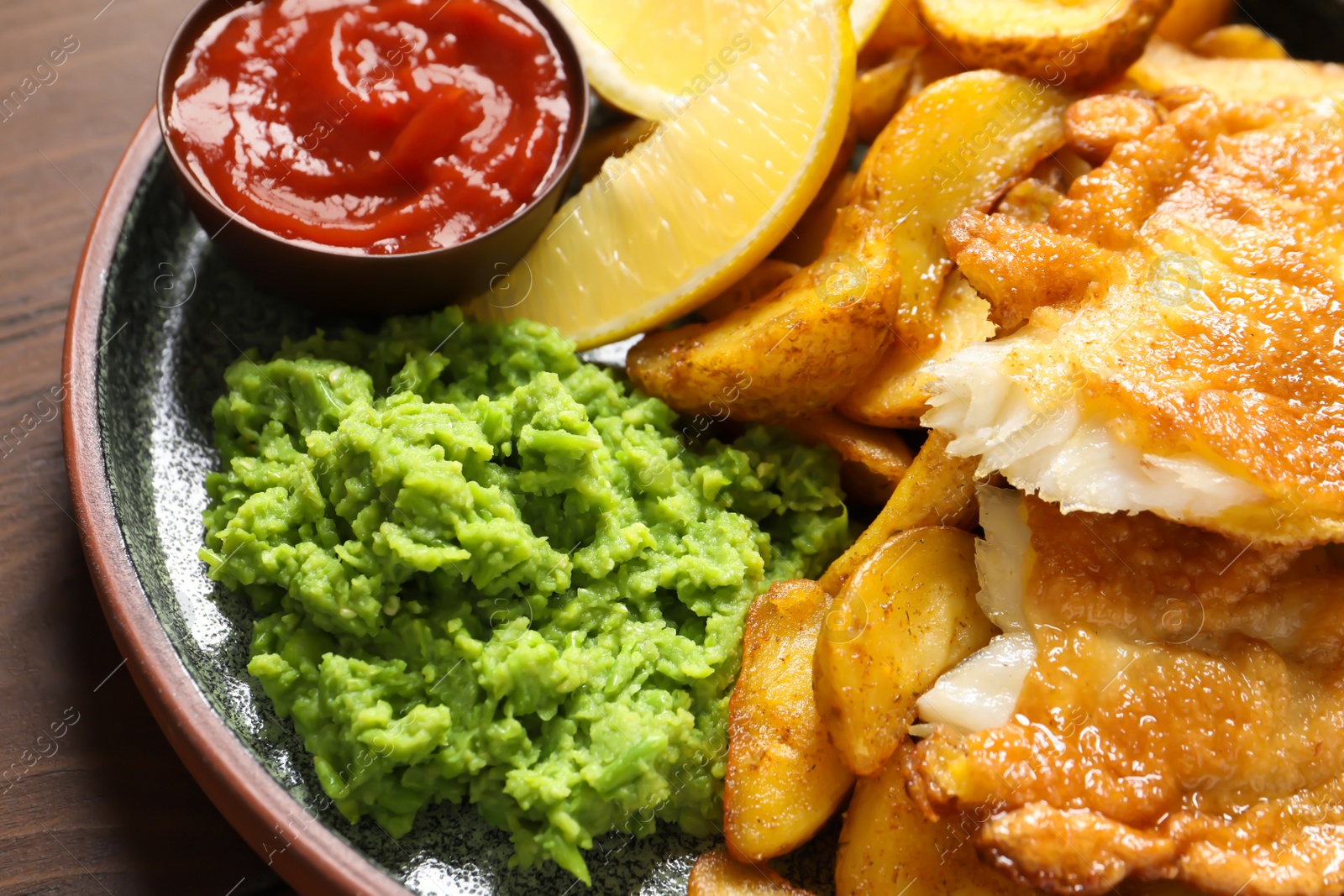 Photo of Plate with British traditional fish and potato chips, closeup