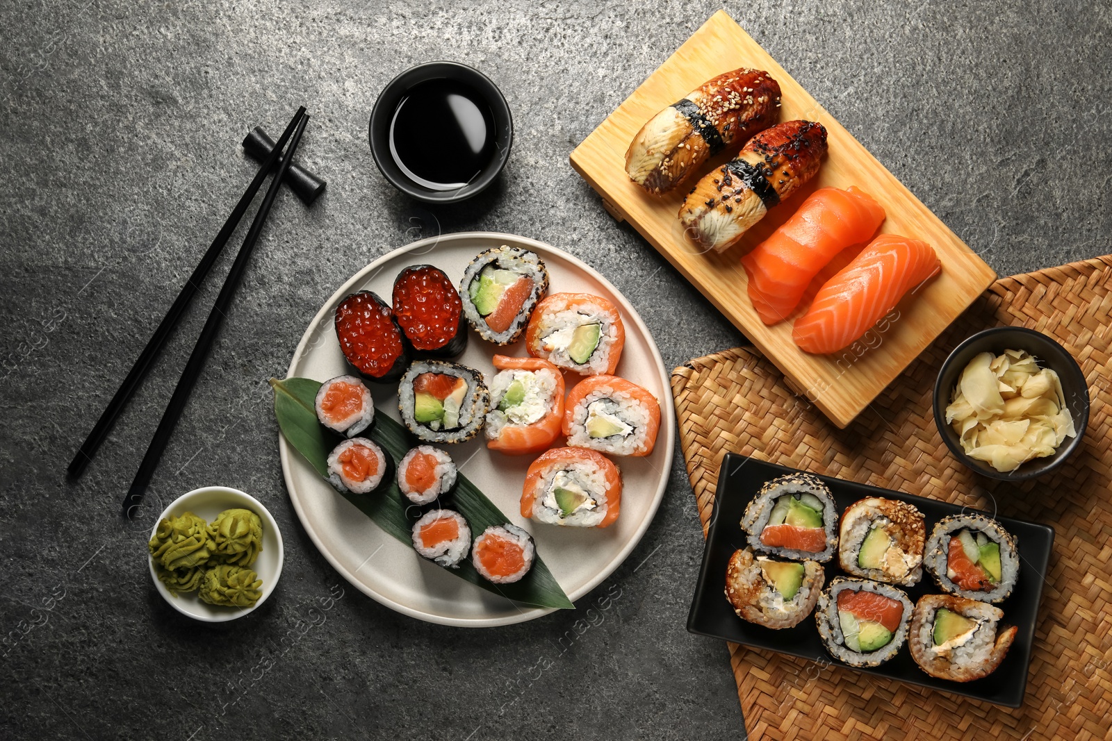 Photo of Flat lay composition with delicious sushi rolls on dark grey table