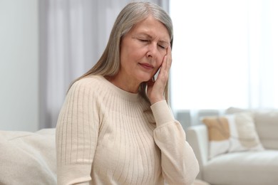 Photo of Overwhelmed woman suffering from headache at home