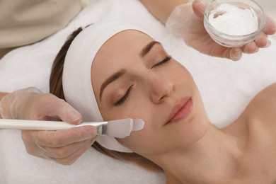 Young woman during face peeling procedure in salon