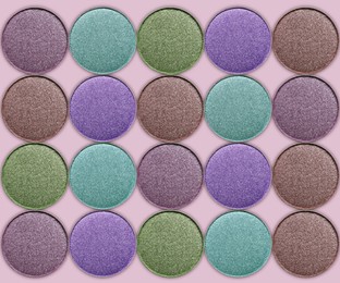 Collage of beautiful different eye shadow refill pans on pastel background