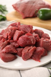 Photo of Plate with pieces of raw beef meat on table, closeup