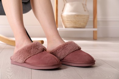 Photo of Woman in warm soft slippers at home, closeup