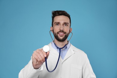Photo of Doctor with stethoscope on light blue background. Cardiology concept