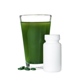 Photo of Glass of spirulina drink and pills on white background
