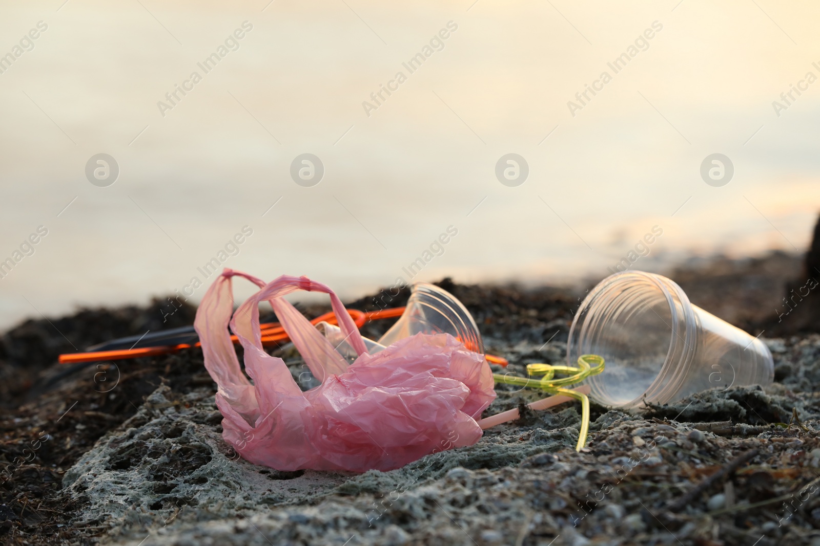 Photo of Plastic garbage at beach, closeup and space for text. Environmental pollution concept