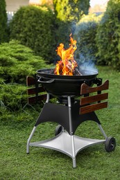 Photo of Portable barbecue grill with fire flames outdoors