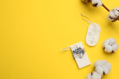 Flat lay composition with scented sachets on yellow background, space for text