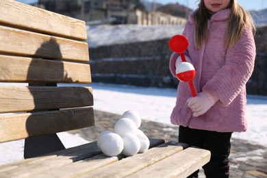 Little girl playing with snowball maker outdoors, closeup