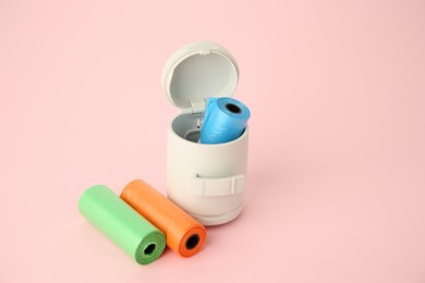 Dog waste bags and dispenser on pink background