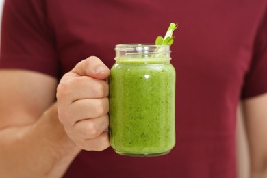 Man holding mason jar with delicious smoothie, closeup