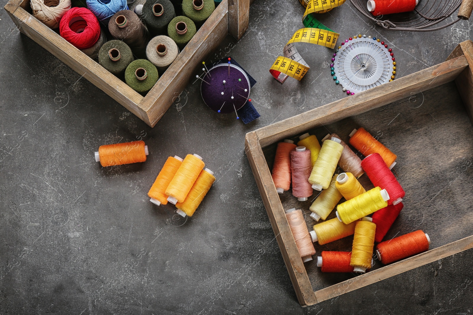 Photo of Boxes with color sewing threads on grey background